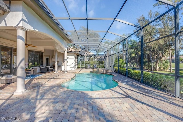 view of swimming pool with ceiling fan, a patio, and glass enclosure