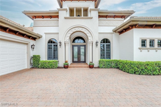 property entrance featuring a garage and french doors