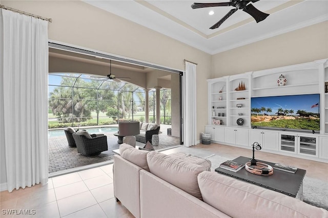 tiled living room featuring ceiling fan and a tray ceiling