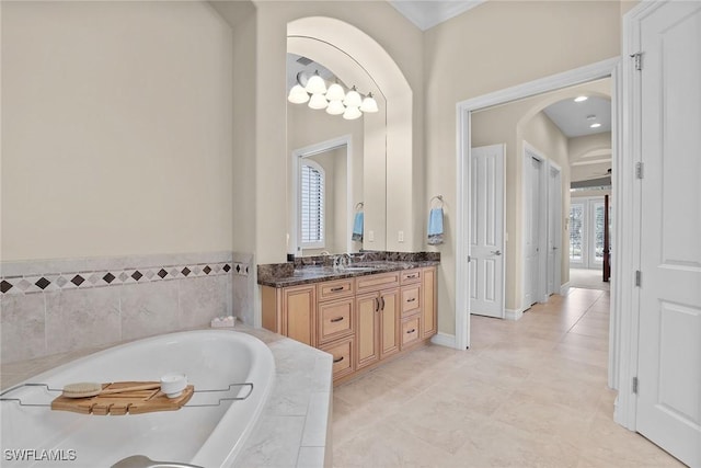 bathroom featuring vanity, tiled tub, and tile patterned floors