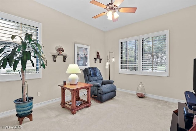 living area with ceiling fan and light colored carpet