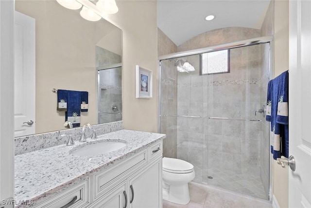 bathroom with vanity, vaulted ceiling, tile patterned floors, toilet, and walk in shower