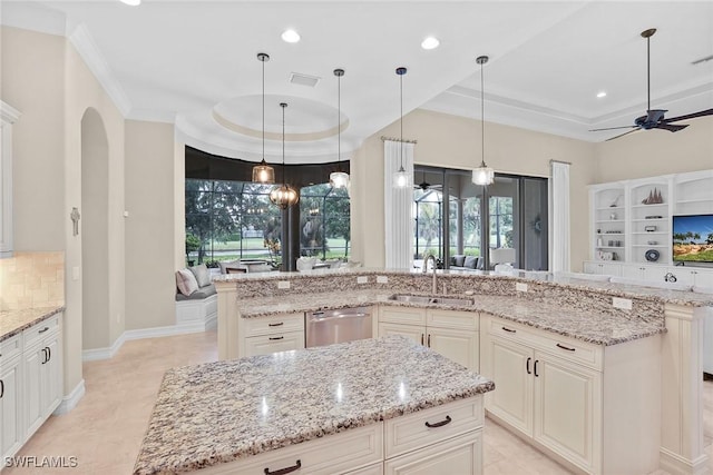 kitchen featuring a large island, a tray ceiling, and sink