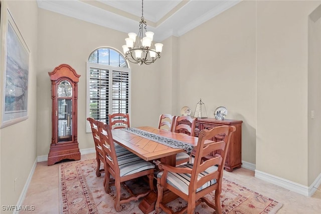 dining area with a tray ceiling, ornamental molding, a chandelier, and light tile patterned flooring