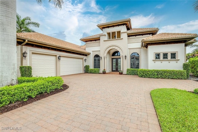 mediterranean / spanish-style home featuring a garage and french doors