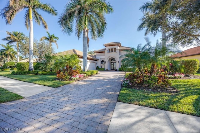 mediterranean / spanish-style home with a garage and a front yard