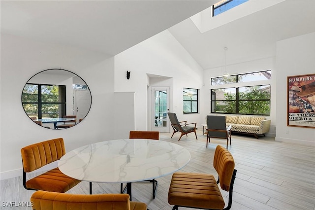 6600 Tannin Ln Unit C, Naples, FL 34109 - dining space with a skylight, high vaulted ceiling, and light hardwood / wood-style floors