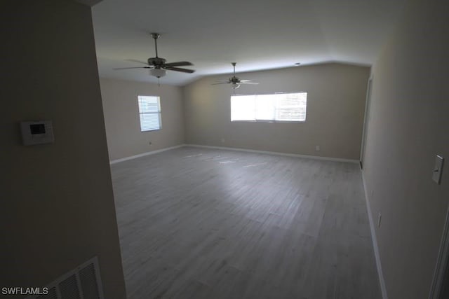 spare room with hardwood / wood-style floors, vaulted ceiling, and ceiling fan