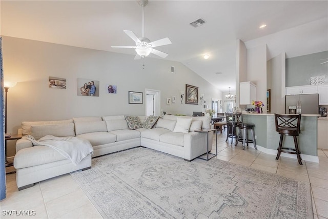 living room with light tile patterned floors, ceiling fan with notable chandelier, and high vaulted ceiling