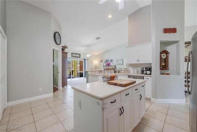 kitchen featuring light tile patterned flooring, high vaulted ceiling, ceiling fan, a kitchen island, and white cabinetry