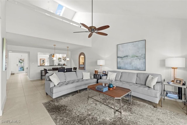 living room featuring high vaulted ceiling, light tile patterned flooring, and a ceiling fan