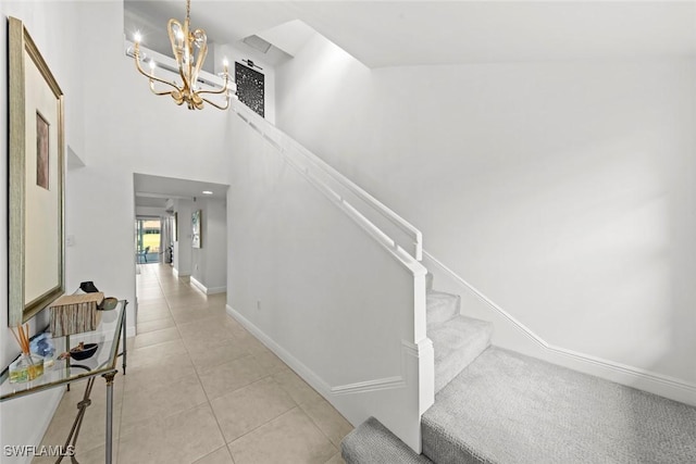 interior space with tile patterned flooring, a towering ceiling, and a notable chandelier