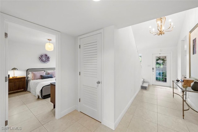 interior space featuring baseboards, an inviting chandelier, and light tile patterned floors