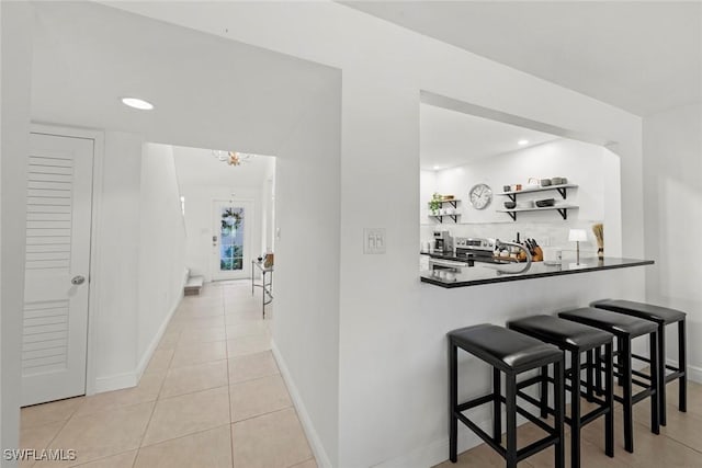 hallway with light tile patterned floors, baseboards, and recessed lighting