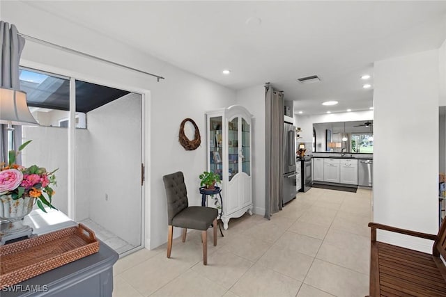 corridor featuring light tile patterned flooring and sink