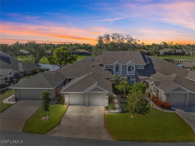 view of front of home with a garage and a lawn