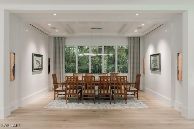 dining area featuring coffered ceiling, beam ceiling, and light hardwood / wood-style flooring