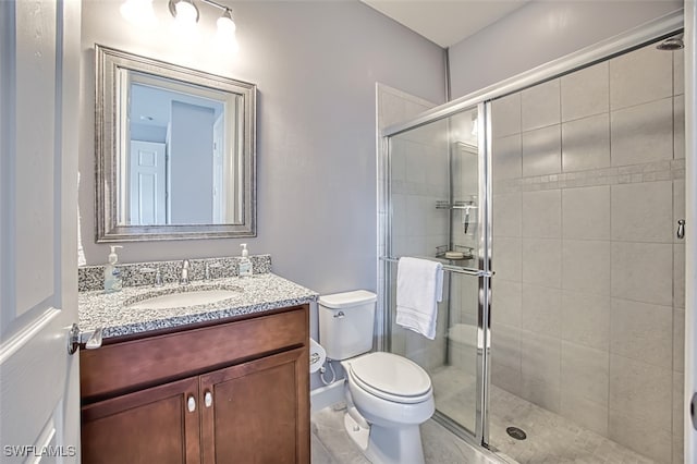 bathroom with vanity, toilet, and a shower with shower door