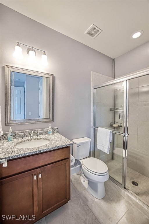 bathroom with tile patterned flooring, vanity, an enclosed shower, and toilet