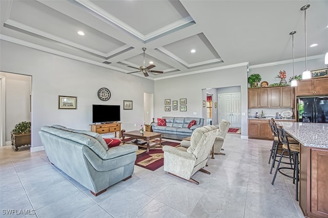 living room featuring a high ceiling, coffered ceiling, ceiling fan, ornamental molding, and beamed ceiling