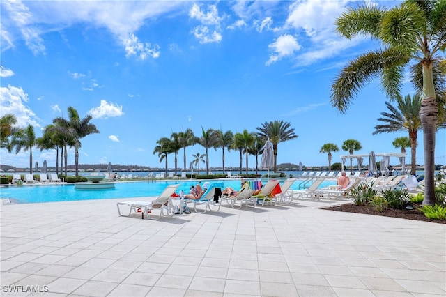 view of pool featuring a patio area and a water view