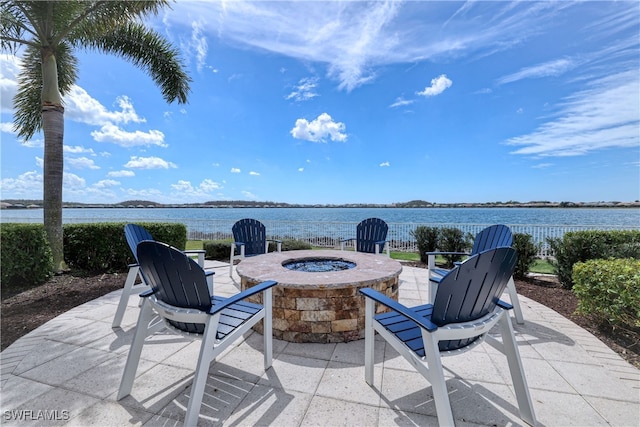 view of patio with a fire pit and a water view