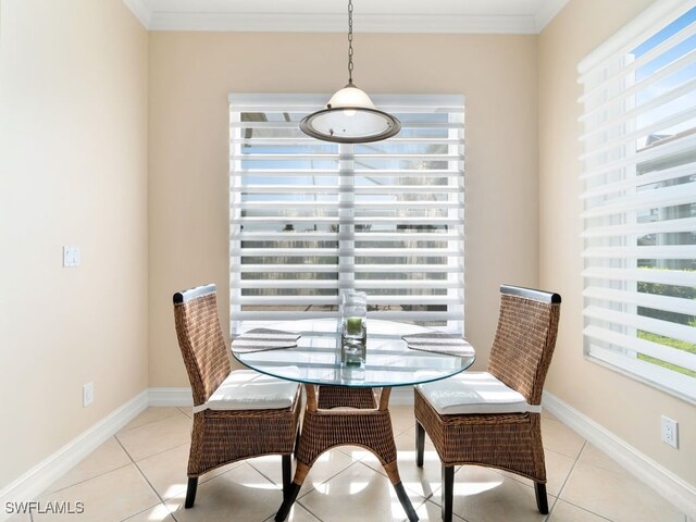 dining space with light tile patterned floors, crown molding, and a wealth of natural light