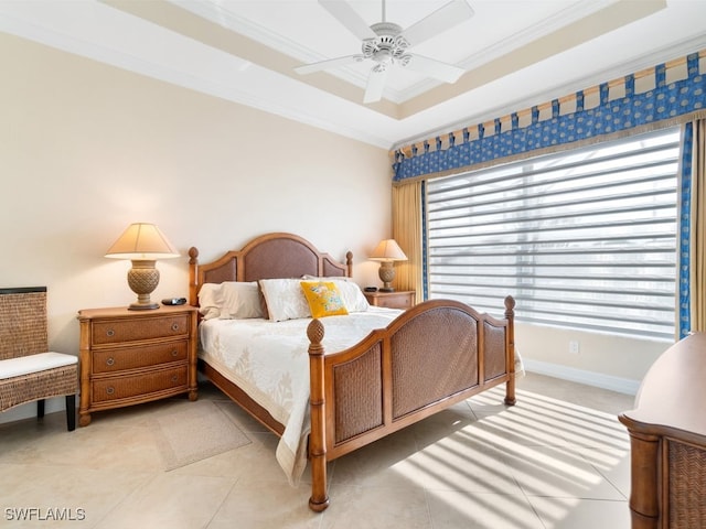 tiled bedroom featuring multiple windows, a tray ceiling, ceiling fan, and ornamental molding