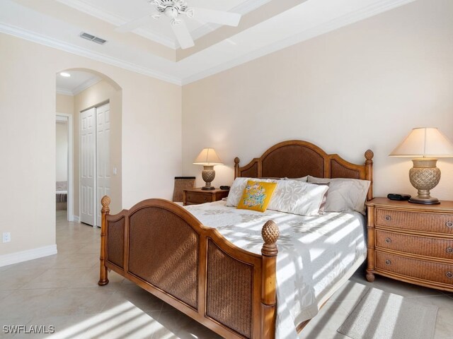 bedroom with ceiling fan, light tile patterned floors, crown molding, and a closet