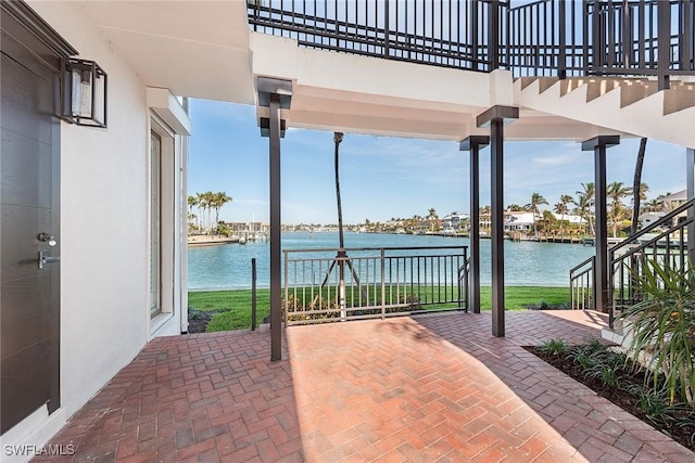 view of patio featuring a balcony and a water view