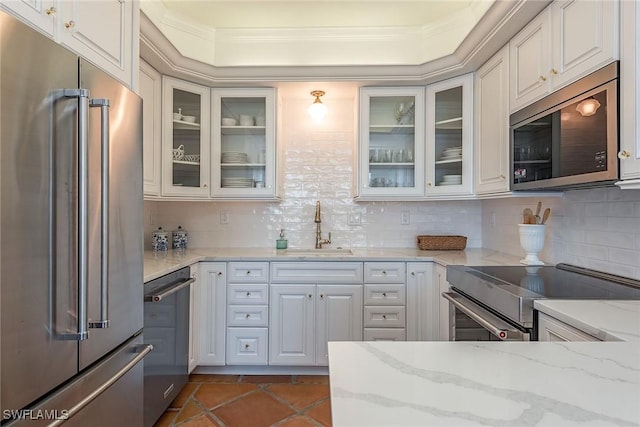 kitchen with white cabinets, sink, light stone countertops, and stainless steel appliances