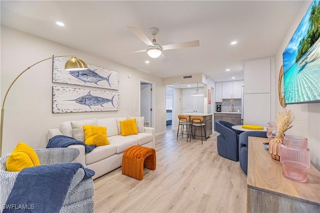 living room featuring ceiling fan and light wood-type flooring