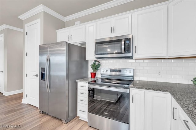 kitchen with backsplash, dark stone countertops, stainless steel appliances, and white cabinetry