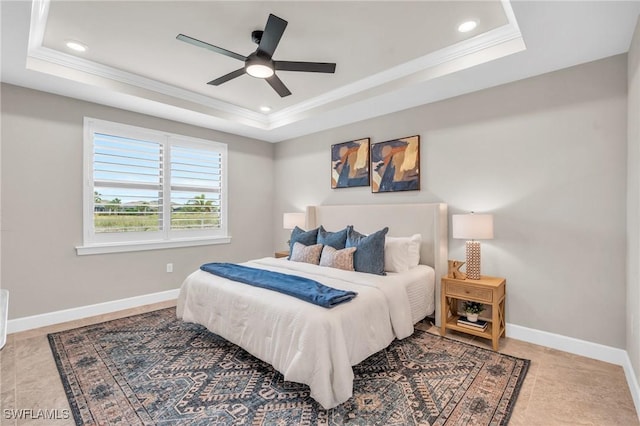 bedroom featuring ceiling fan, a tray ceiling, and ornamental molding