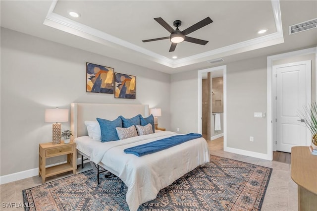 bedroom featuring ceiling fan, ensuite bathroom, ornamental molding, and a tray ceiling