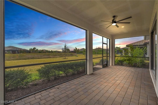 unfurnished sunroom with ceiling fan