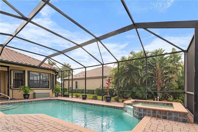 view of swimming pool featuring glass enclosure, an in ground hot tub, and a patio