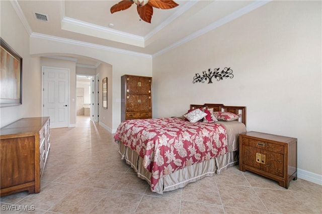 tiled bedroom featuring ceiling fan, a tray ceiling, and ornamental molding