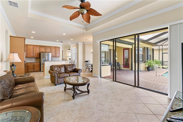 living room with ceiling fan, light tile patterned floors, and a tray ceiling