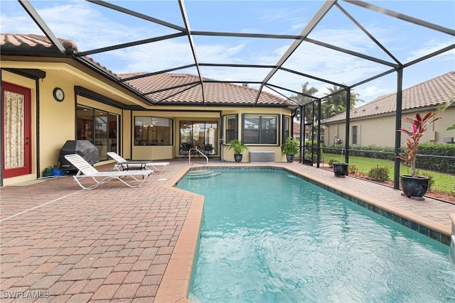 view of pool featuring a lanai, a patio area, and a grill