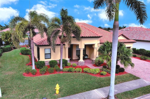 mediterranean / spanish-style home with a front yard