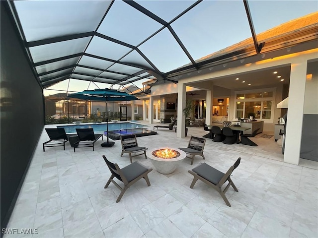 view of patio / terrace with an outdoor living space with a fire pit and a lanai