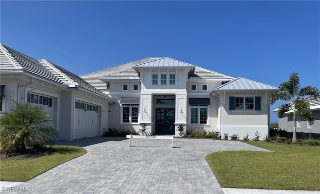 view of front of house featuring a front yard, french doors, and a garage