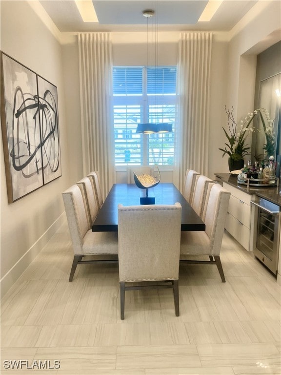 dining area with crown molding and beverage cooler