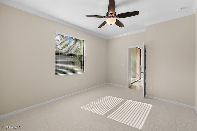 empty room with ceiling fan, light colored carpet, and ornamental molding