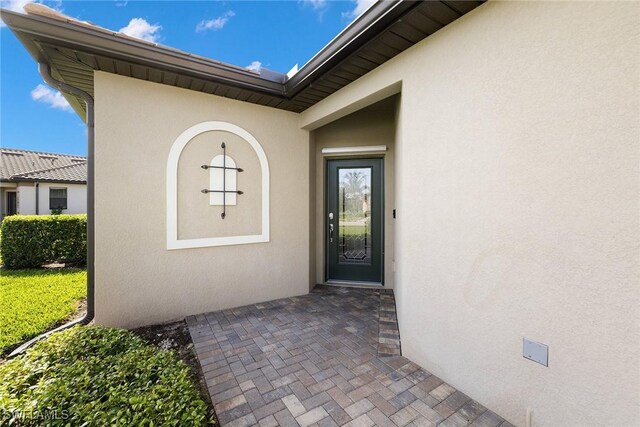 view of exterior entry with stucco siding