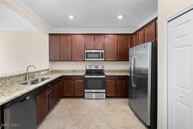 kitchen with light stone counters, a peninsula, a sink, ornamental molding, and appliances with stainless steel finishes
