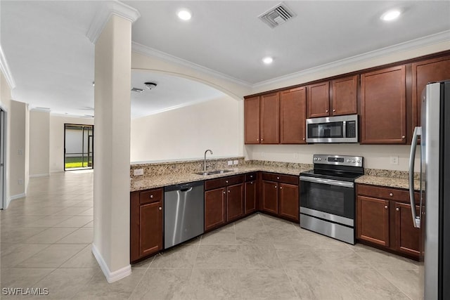 kitchen featuring visible vents, appliances with stainless steel finishes, ornamental molding, a sink, and light stone countertops