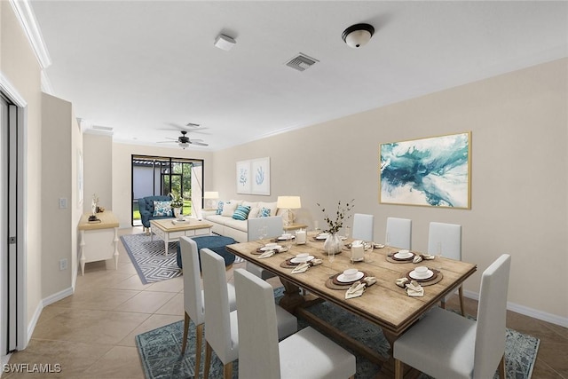 dining room featuring ceiling fan, light tile patterned flooring, visible vents, baseboards, and crown molding