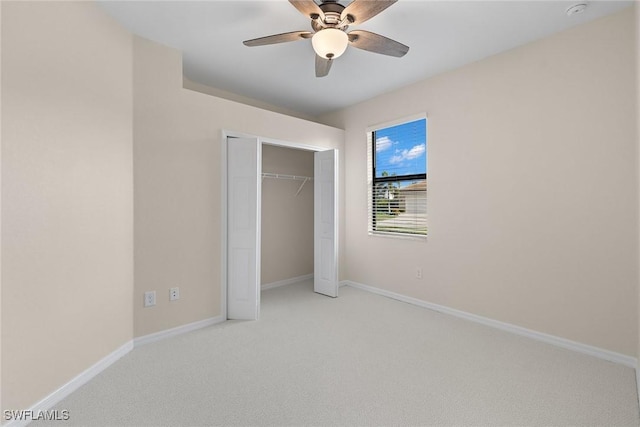 unfurnished bedroom featuring light carpet, ceiling fan, a closet, and baseboards